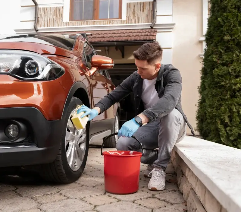 Lavage auto à domicile Ferney-Voltaire : professionnel intervenant sur un véhicule
